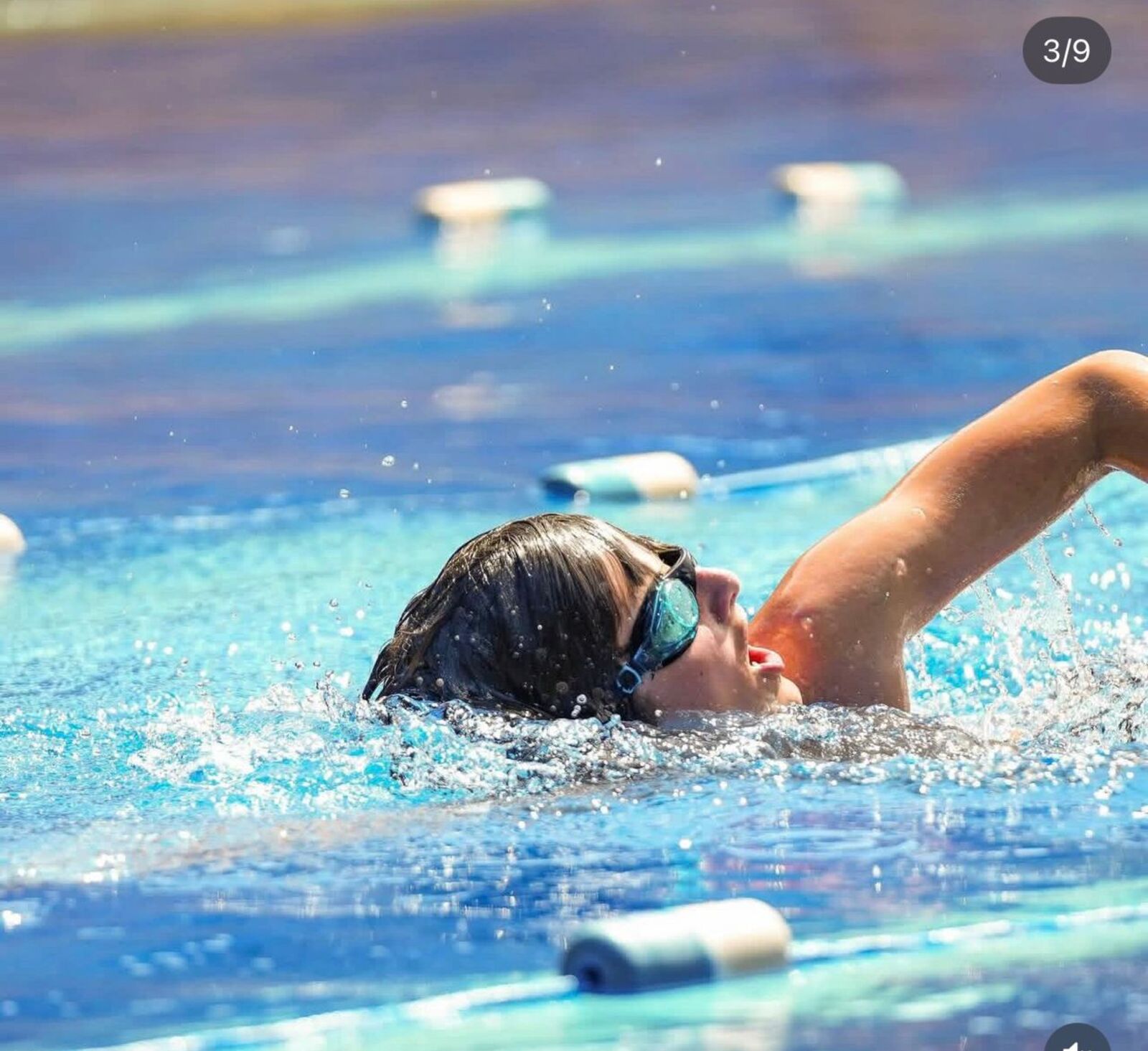 Swimmer practicing freestyle stroke in clear blue pool