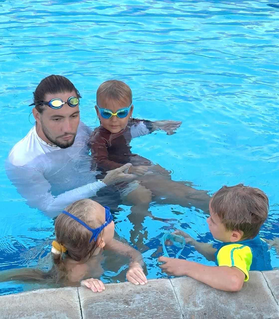 Coach teaching a group of kids by the pool in Bali